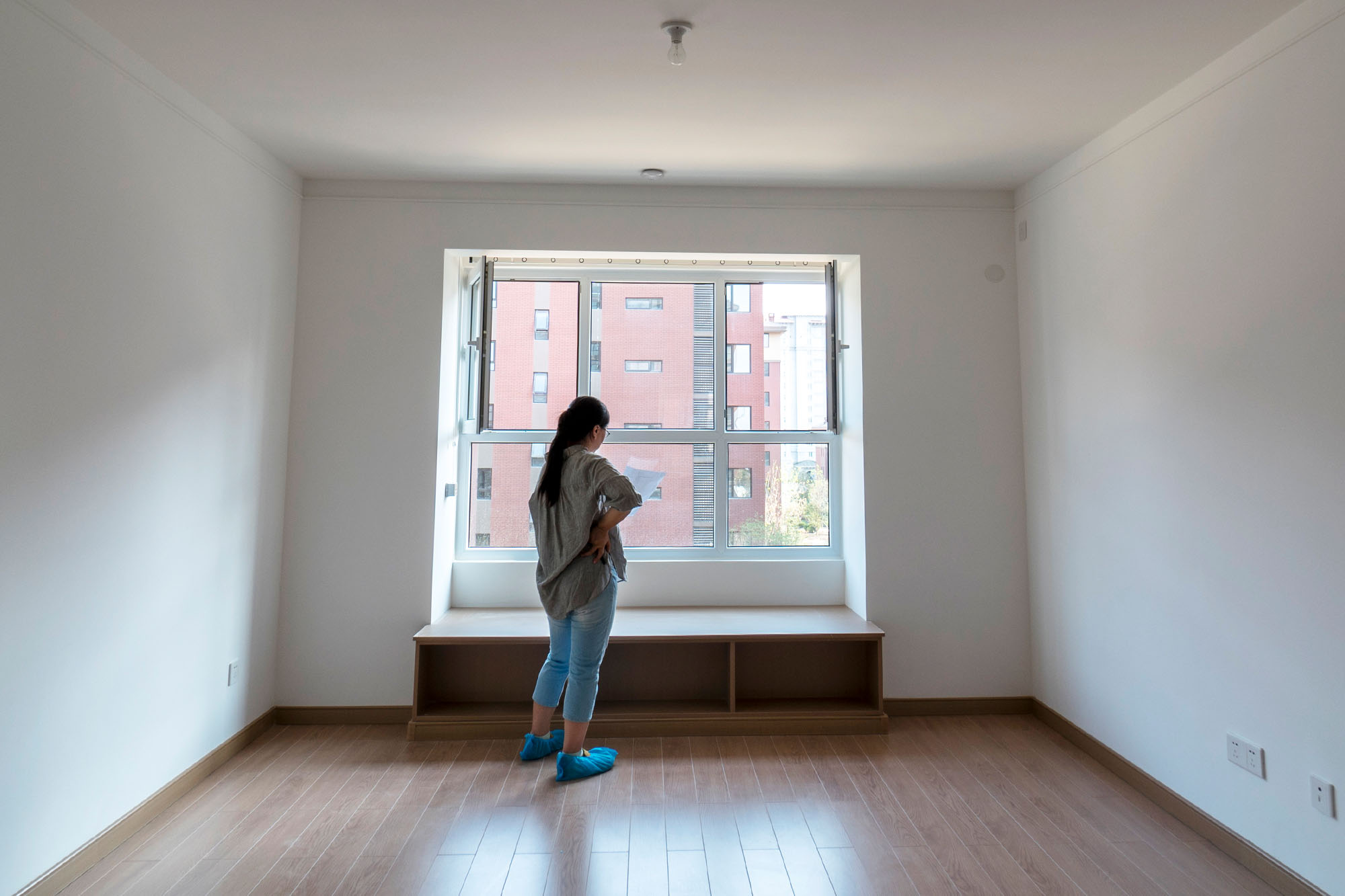Young woman reading a paper in an empty new apartment