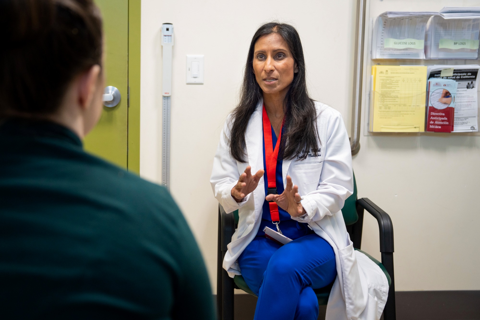 reducing disparities Medi-Cal plans. A doctor meets with a patient in an exam room.