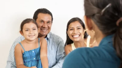 Happy Latino family sits with a medical provider