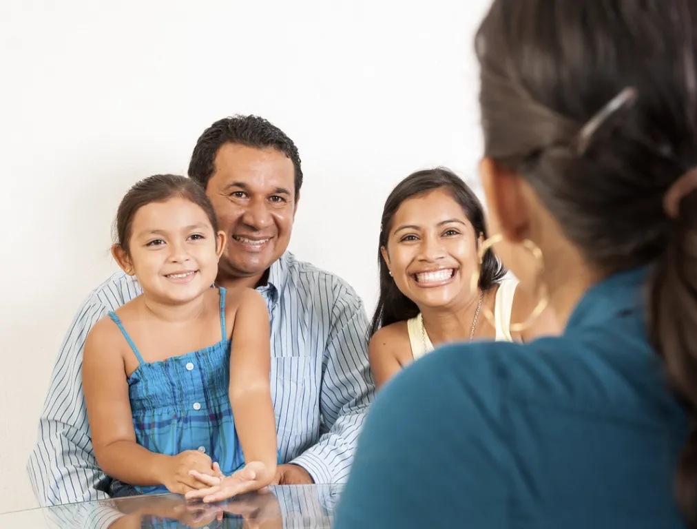 Happy Latino family sits with a medical provider